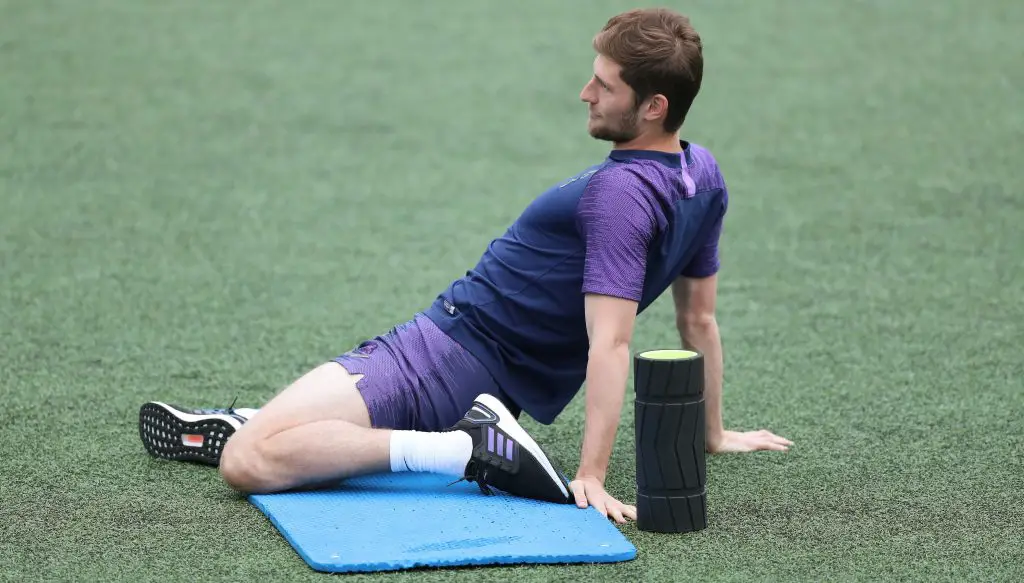 Ben Davies stretching his muscles during a Tottenham training session.