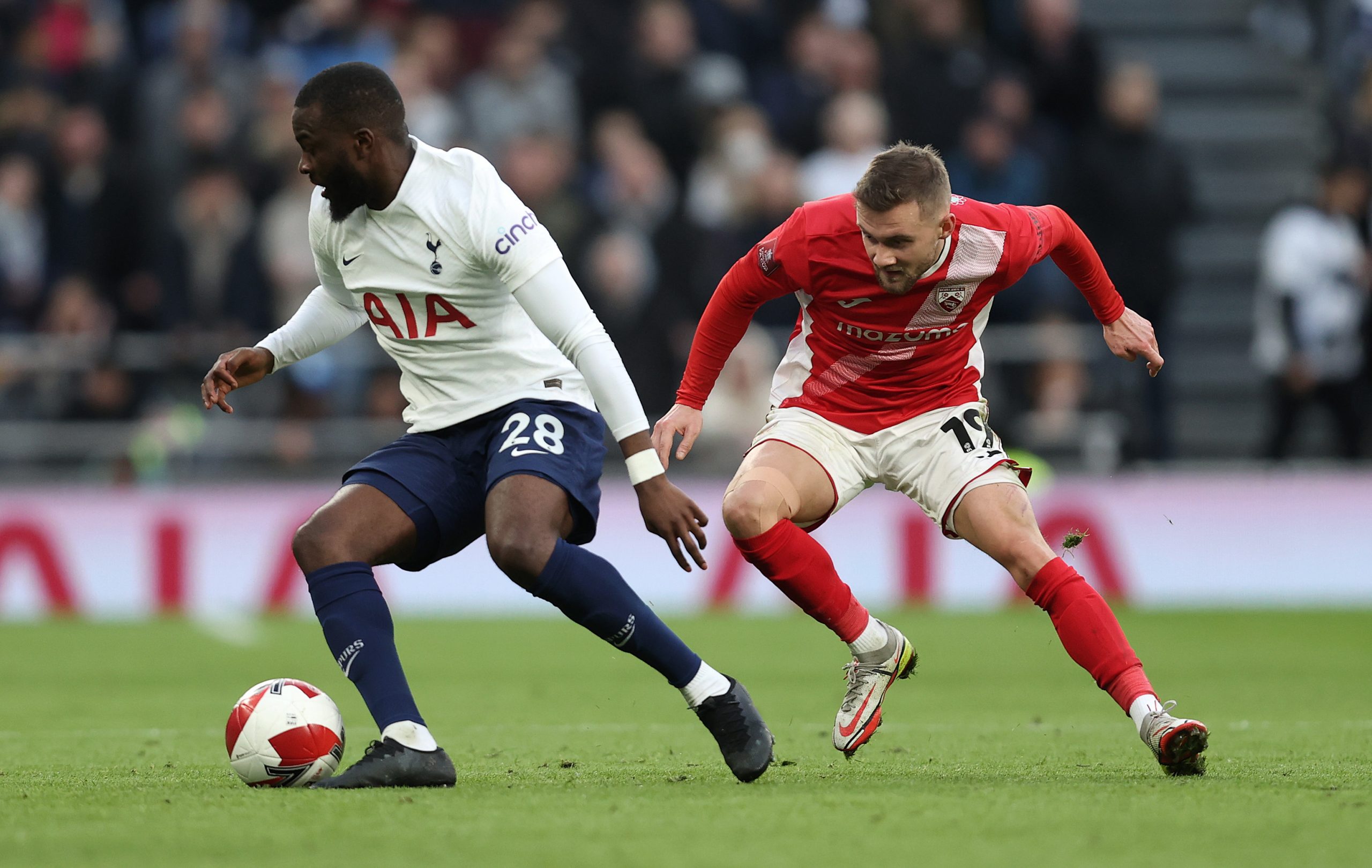 Tanguy Ndombele of Spurs battles with Shane McLoughlin of Morcambe.
