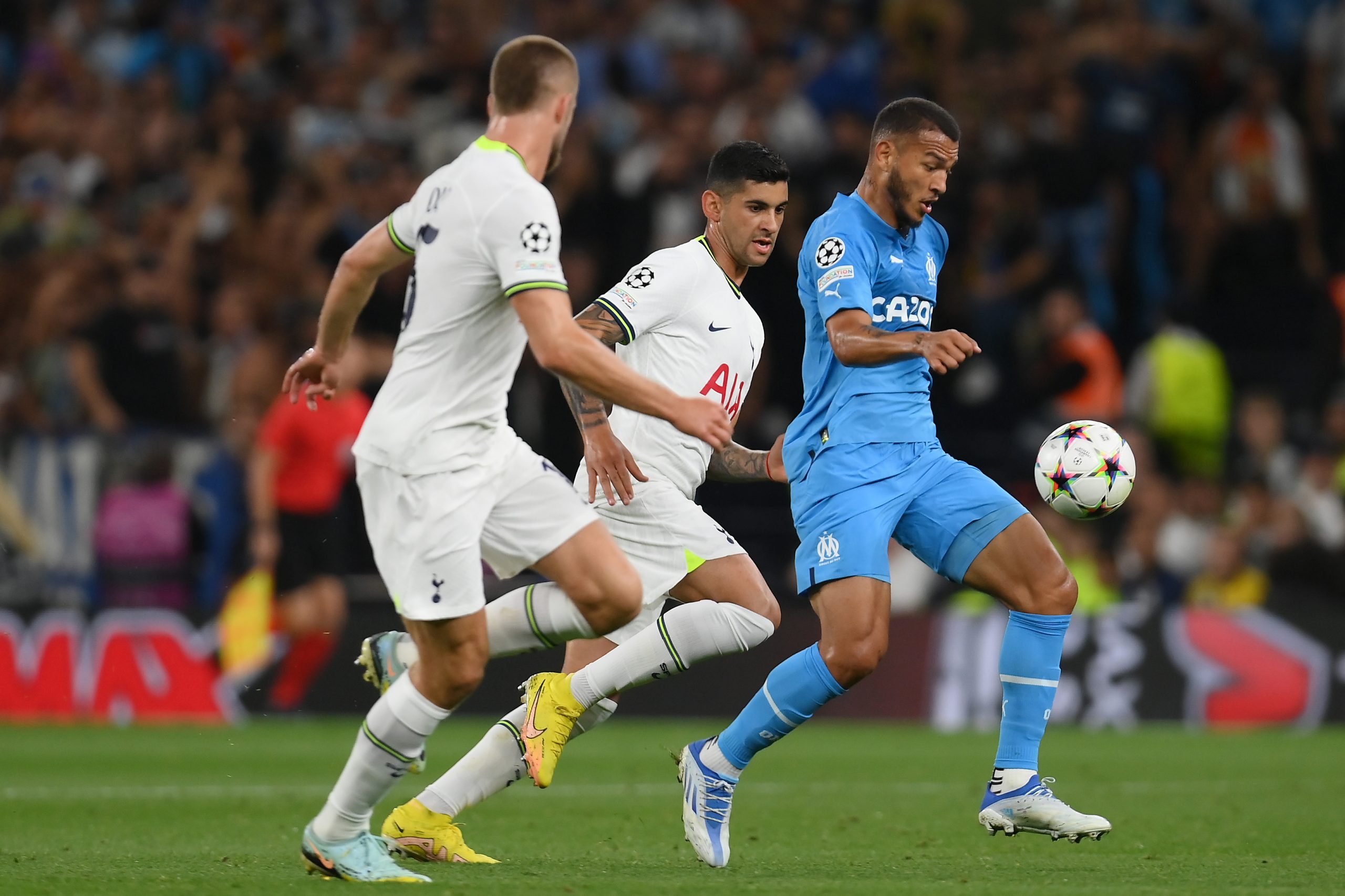 Luis Suarez of Marseille is challenged by Eric Dier and Cristian Romero of Tottenham Hotspur.