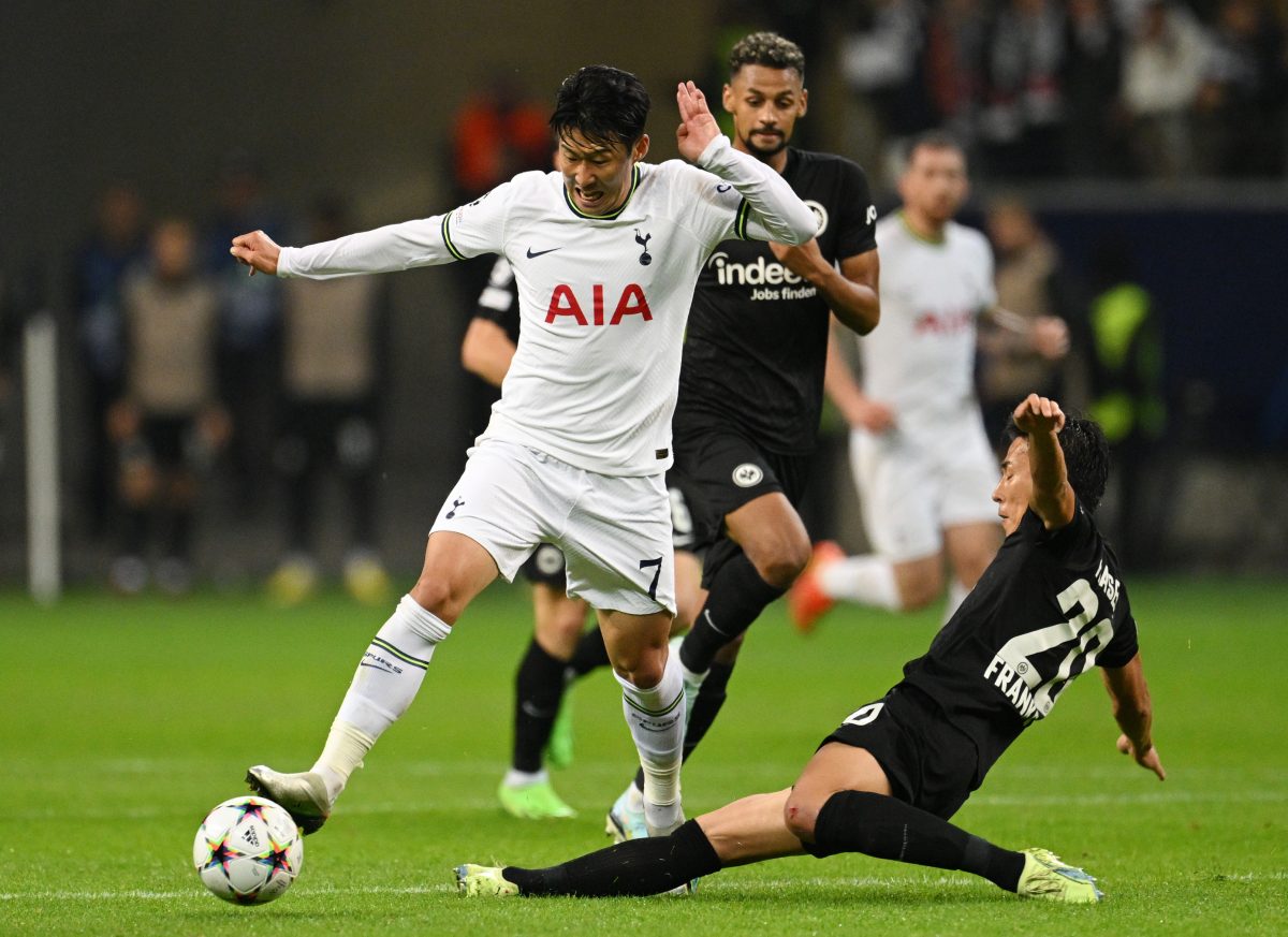 Son Heung-Min of Tottenham Hotspur runs with the ball while challenged by Makoto Hasebe of Eintracht Frankfurt. 