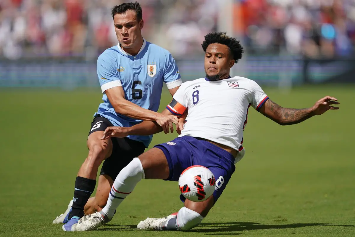 Manuel Ugarte of Uruguay has the ball knocked away by Weston McKennie of USA.