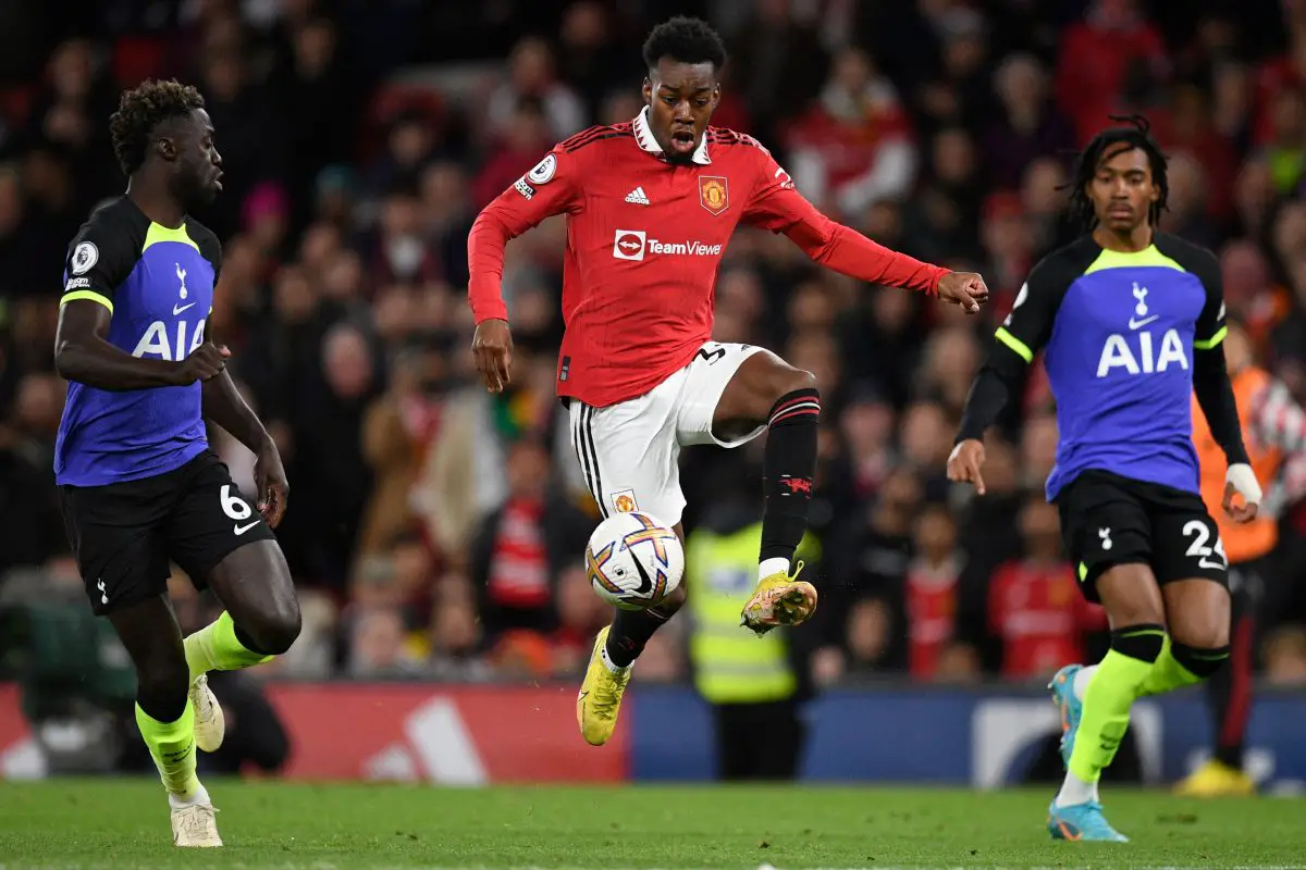 Davinson Sanchez and Djed Spence of Tottenham Hotspur watch as Anthony Elanga of Manchester United controls the ball.