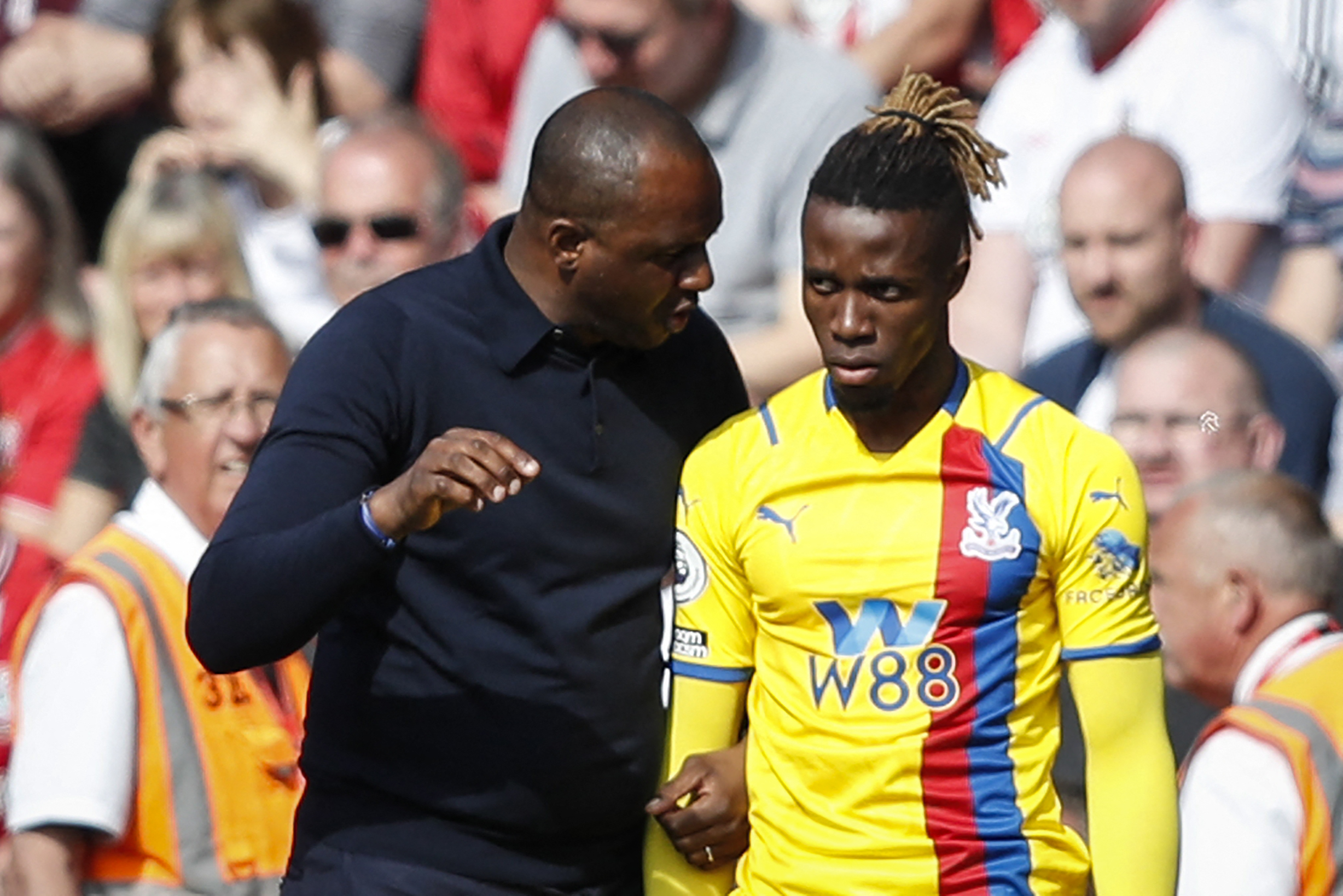 Crystal Palace's French manager Patrick Vieira (L) speaks to Crystal Palace's Ivorian striker Wilfried Zaha.