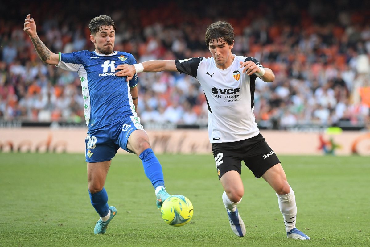 Real Betis' Rodri and Valencia's Jesus Vazquez in action. (Photo by JOSE JORDAN/AFP via Getty Images)