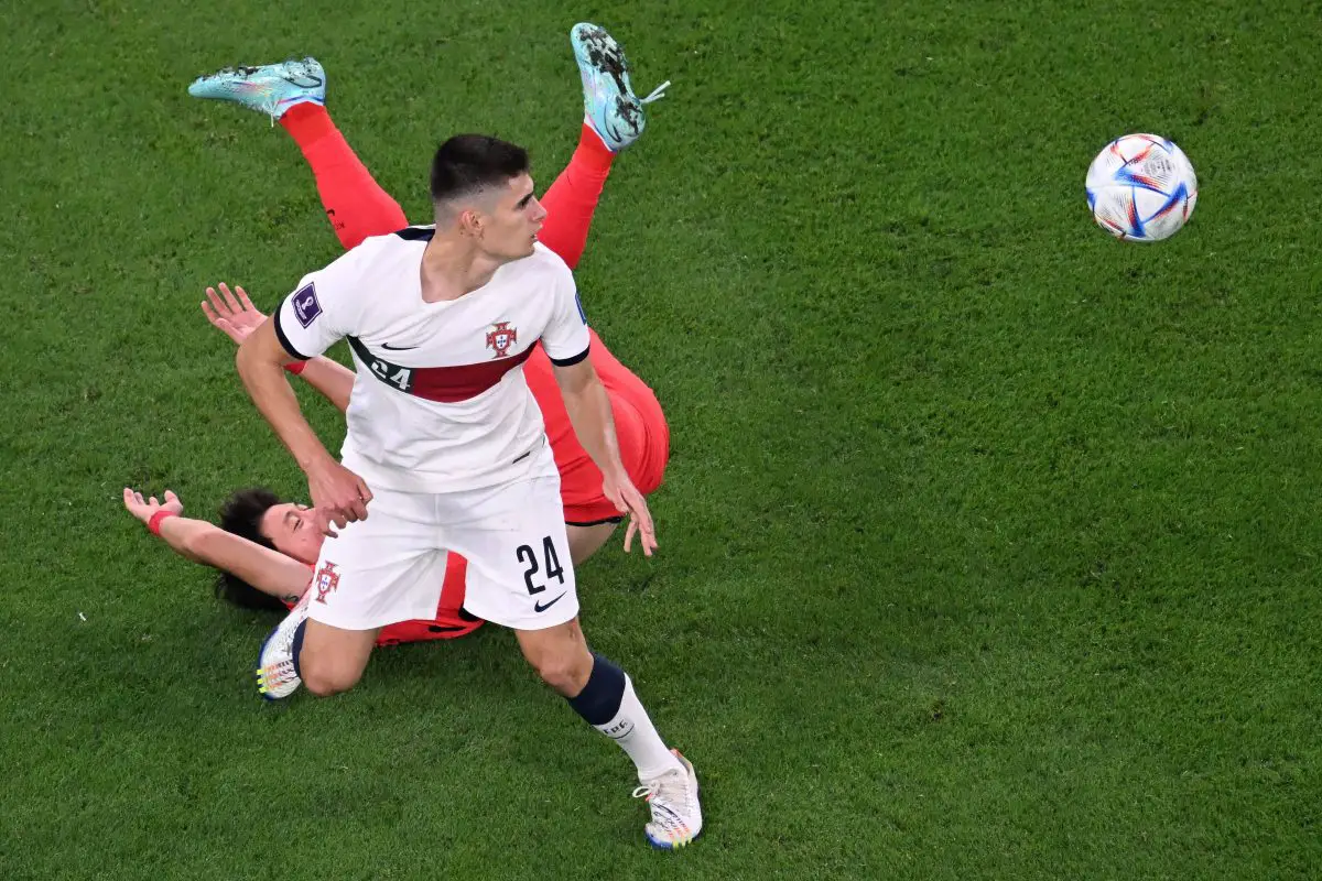 South Korea's Hwang Ui-jo falls as he fights for the ball with Portugal's Antonio Silva. 
