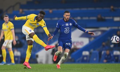 Yves Bissouma of Brighton and Hove Albion takes a shot under pressure from Hakim Ziyech of Chelsea.