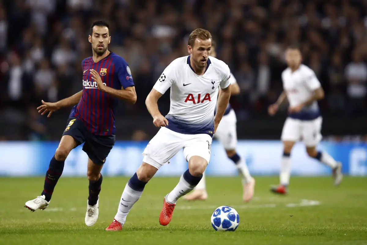 Harry Kane of Tottenham Hotspur runs with the ball under pressure form Sergio Busquets of Barcelona.