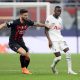 Pape Matar Sarr of Tottenham Hotspur passes the ball whilst under pressure from Olivier Giroud of AC Milan.