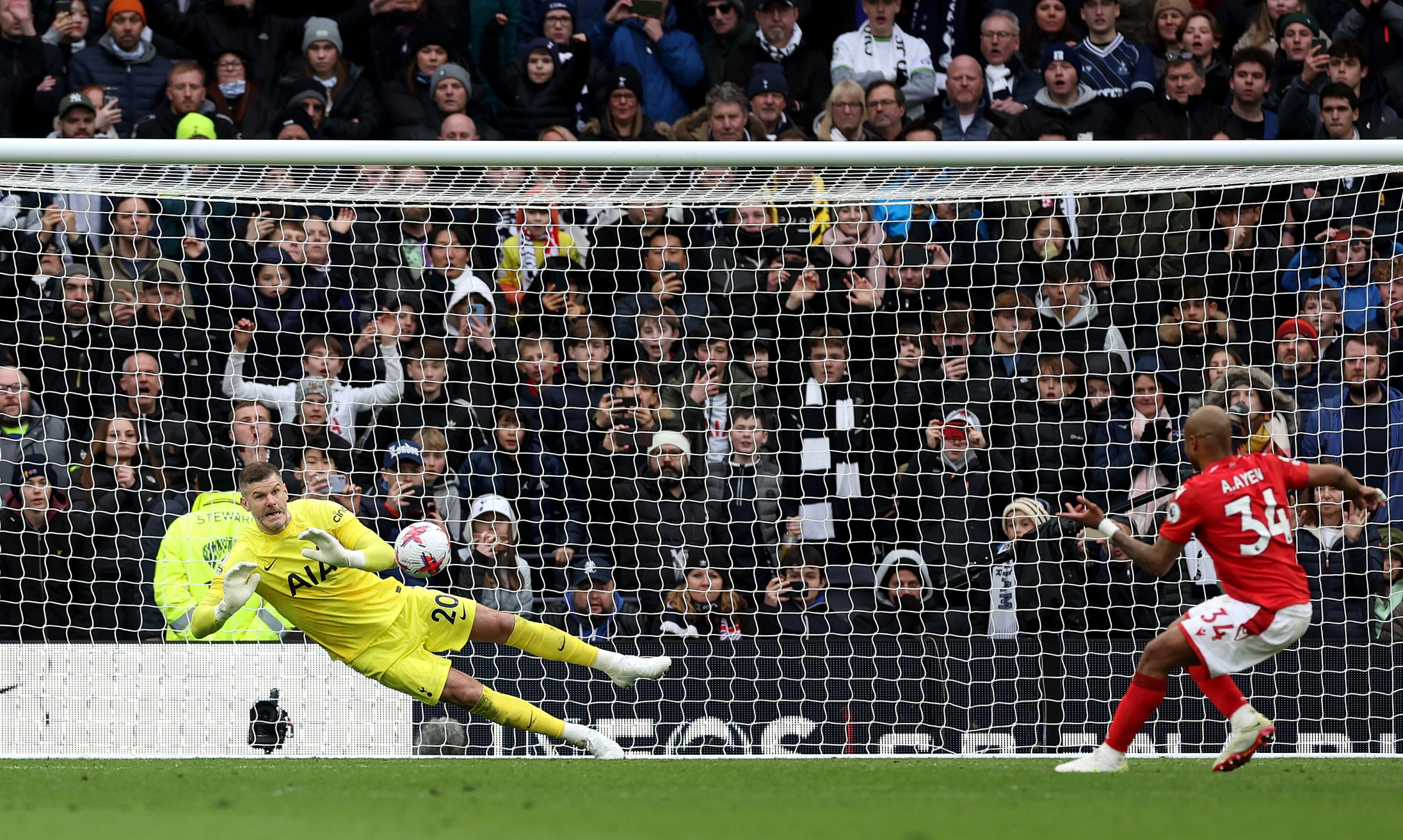 Fraser Forster of Tottenham Hotspur saves a penalty from Andre Ayew of Nottingham Forest.