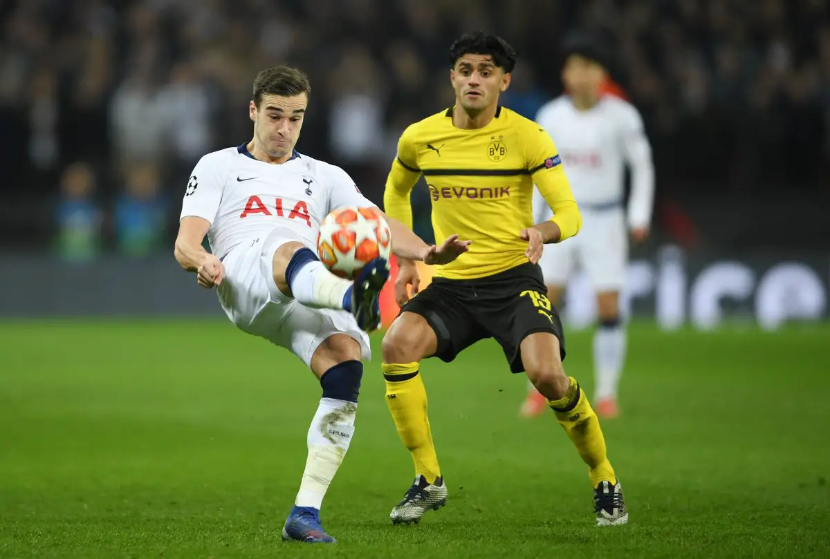 Harry Winks of Tottenham Hotspur clears the ball while under pressure from Mahmoud Dahoud of Borussia Dortmund.  