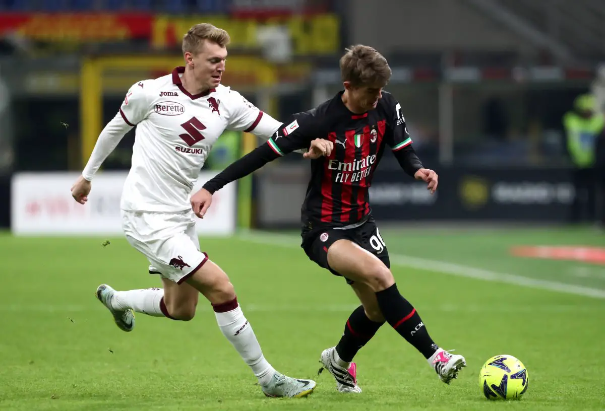 Charles De Ketelaere of AC Milan runs with the ball whilst under pressure from Perr Schuurs of Torino FC.