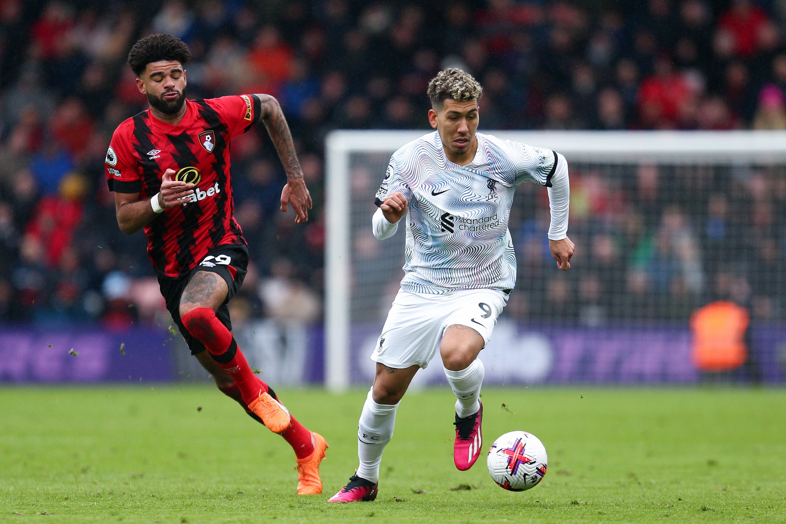 Roberto Firmino of Liverpool runs with the ball whilst under pressure from Philip Billing of AFC Bournemouth during his team's 1-0 loss away from home.