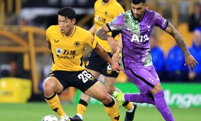 Hwang Hee-chan of Wolverhampton Wanderers runs from Cristian Romero of Tottenham Hotspur.