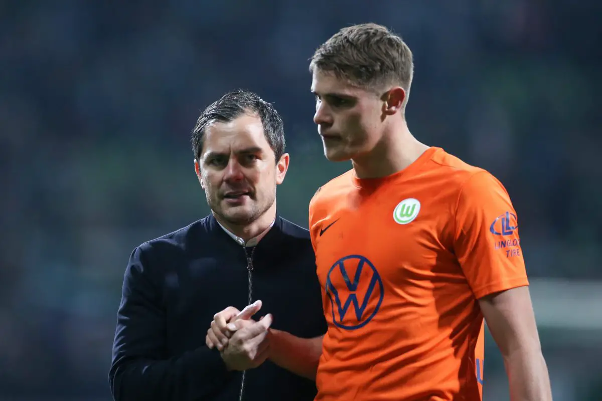 Sporting director Marcel Schaefer of VfL Wolfsburg shakes hands with Micky van de Ven. 