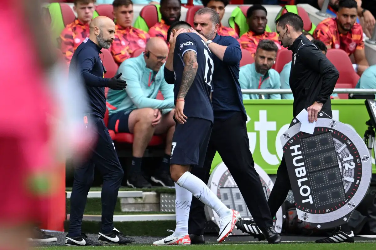 Tottenham Hotspur's Greek-Australian coach Ange Postecoglou Cristian Romero (C) as he leaves the game injured after scoring the opening goal against Brentford.