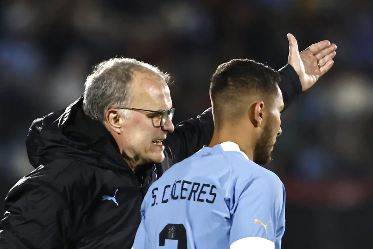 Marcelo Bielsa, the head coach of Uruguay, gives instructions to his player Sebastian Caceres.