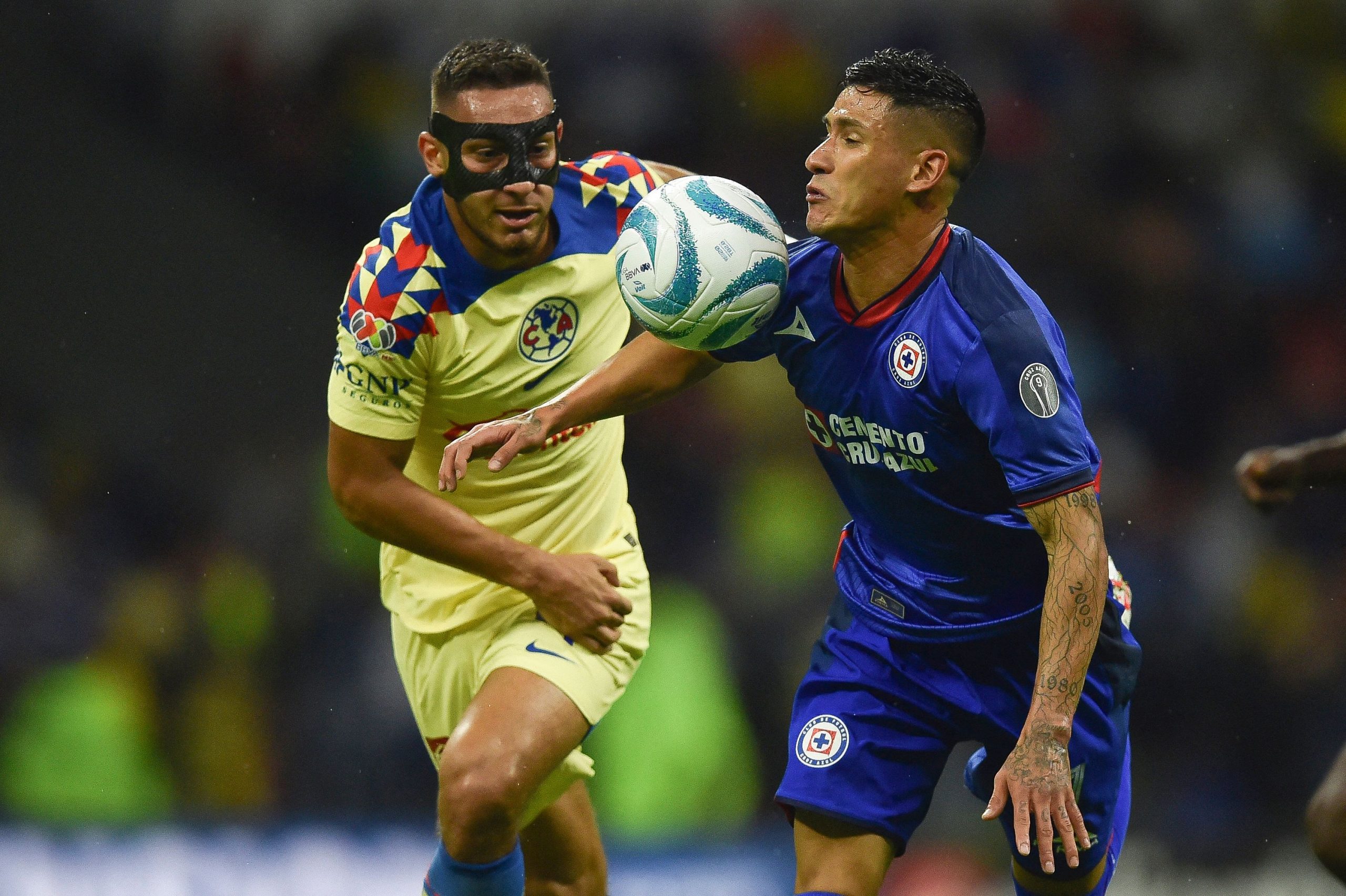 America's defender Sebastian Caceres (L) fights for the ball with Cruz Azul's forward Carlos Antuna. (Photo by RODRIGO OROPEZA/AFP via Getty Images)