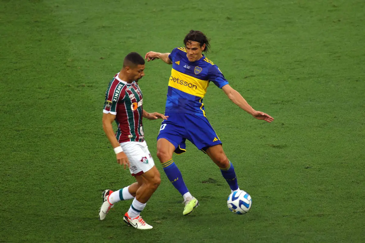 Fluminense's midfielder Andre Trindade (L) and Boca Juniors' Uruguayan forward Edinson Cavani fight for the ball. 